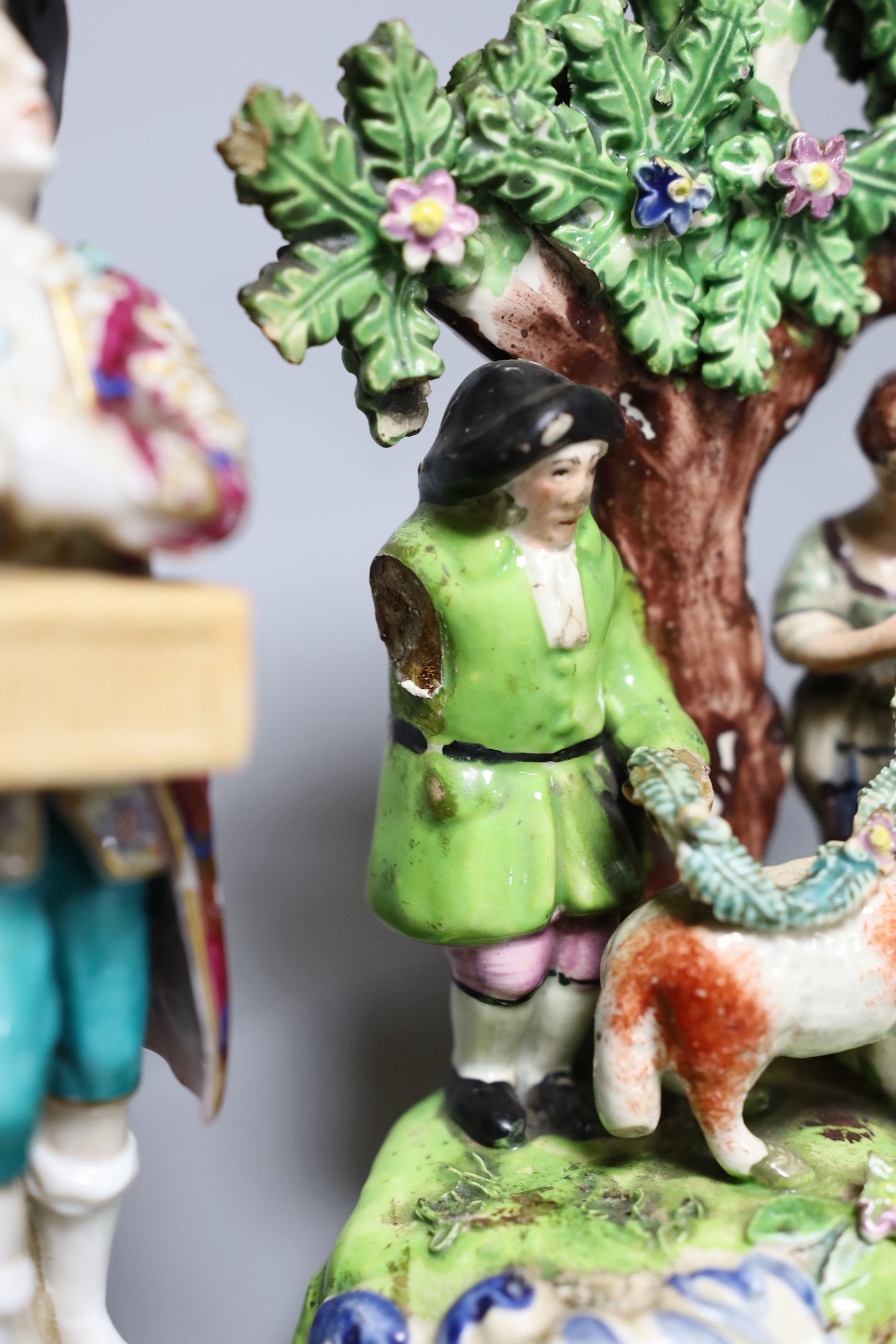 A Walton pearlware group ‘Tenderness’, a Walton type pearlware group of a couple, c.1820, and two Continental porcelain figures, tallest 18.5cm